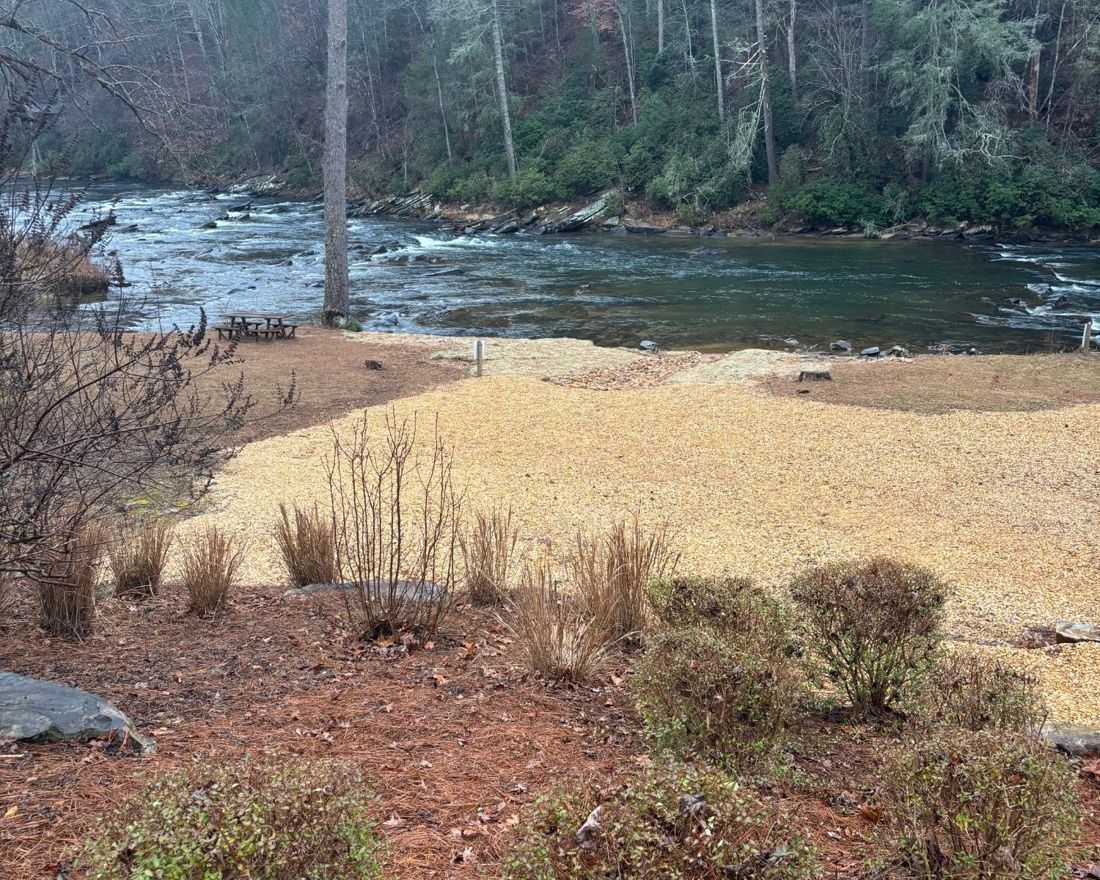 A north Georgia riverbank cleared of vegetation and covered in gravel to the water's edge
